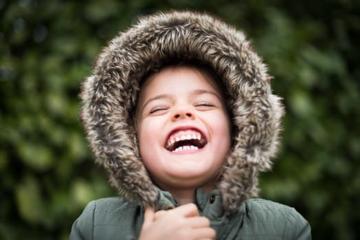 Lachend kind met winterjas