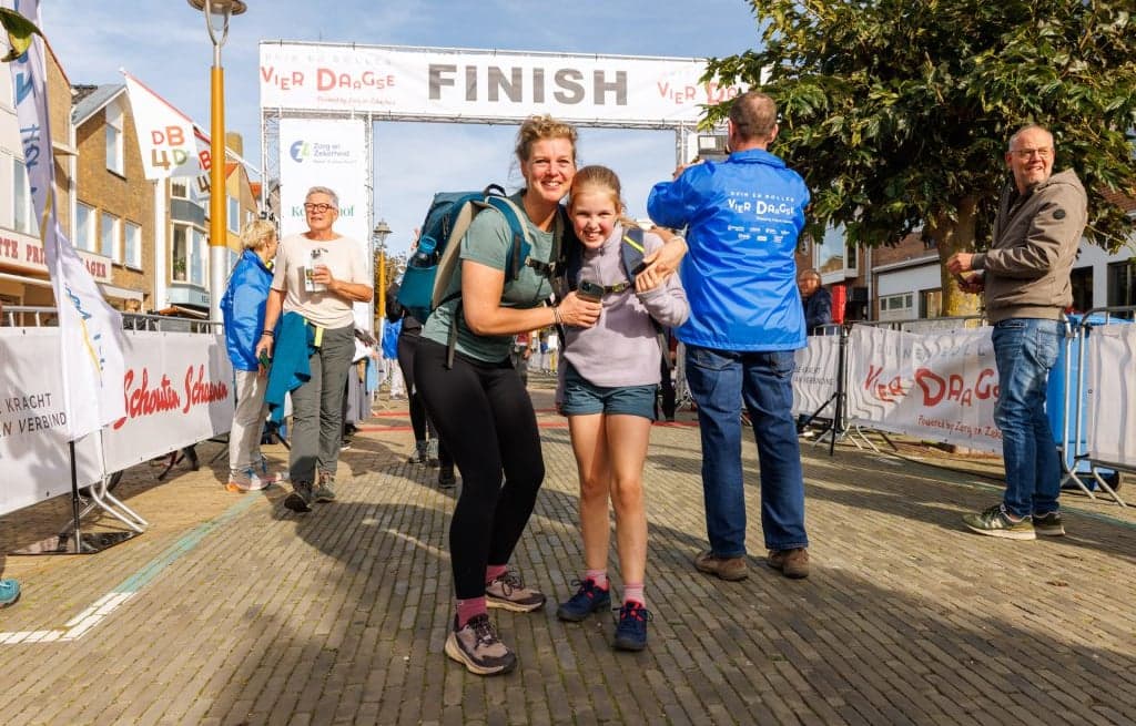 Finish van marathon, vrouw met kind